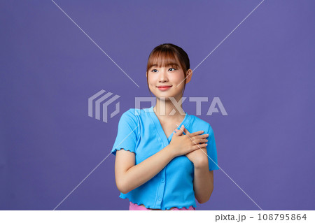 Happy nice charming woman hold hands heart honest smile isolated on purple color background Happy nice charming woman hold hands heart honest smile isolated on purple color background 108795864