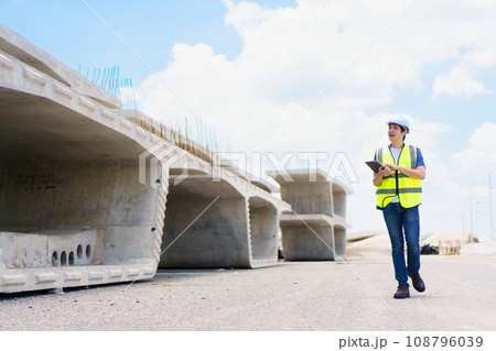 Professional senior Asian civil engineer working at the heavy infrastructure construction site, civil engineer - foreman inspecting the segmentation construction bridge. 108796039