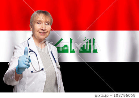 Iraqi smiling mature doctor woman holding stethoscope on flag of Iraq background Iraqi smiling mature doctor woman holding stethoscope on flag of Iraq background 108796059
