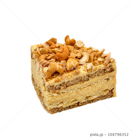 A piece of Cashew cake based on protein layers with cashews, custard and chocolate isolated on white 108796352