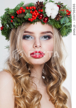 Young model woman with long wavy hair, makeup and colorful natural winter decoration Young model woman with long wavy hair, makeup and colorful natural winter decoration 108796666