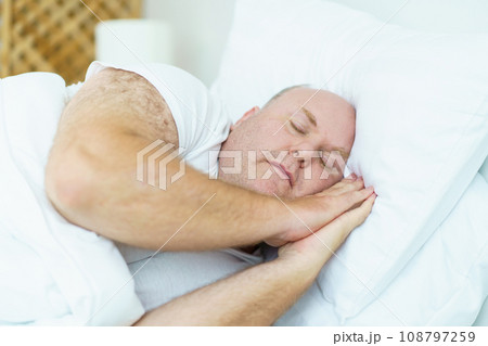 Caucasian white oversize body - fat man sleeping on the bed in bedroom close up. Health care and wellbeing concept. 108797259