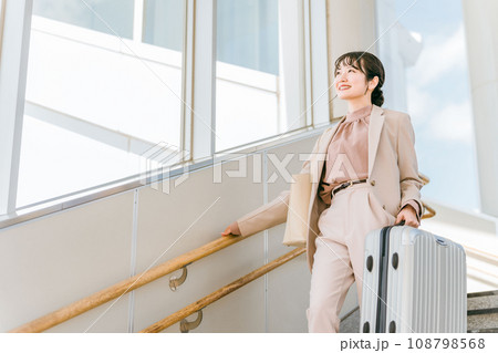 階段をスーツケースを持って降りる女性（ながらトレーニング・筋トレ） 108798568