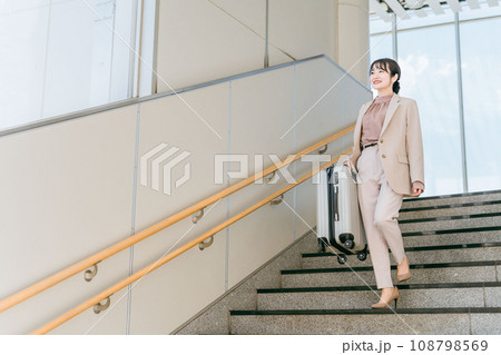 階段をスーツケースを持って降りる女性(ながらトレーニング・筋トレ) 階段をスーツケースを持って降りる女性(ながらトレーニング・筋トレ) 108798569