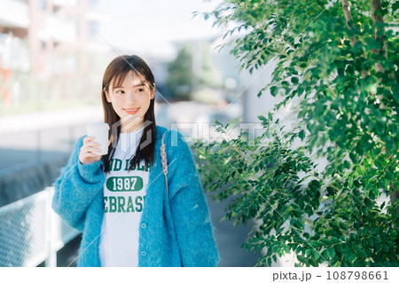 コーヒーを持ちながら街ブラする女性 108798661