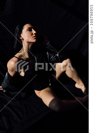 Portrait of a beautiful brunette woman on a black background 108798955