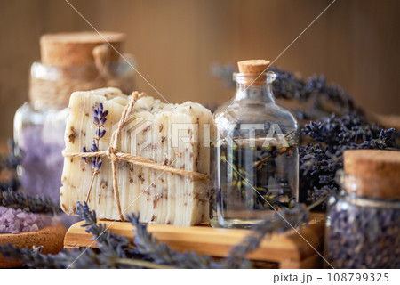 Wellness treatments with lavender flowers on wooden table. Spa still-life. Essential oils, sea salt and handmade soap. Natural herb cosmetic with lavender flowers Wellness treatments with lavender flowers on wooden table. Spa still-life. Essential oils, sea salt and handmade soap. Natural herb cosmetic with lavender flowers 108799325