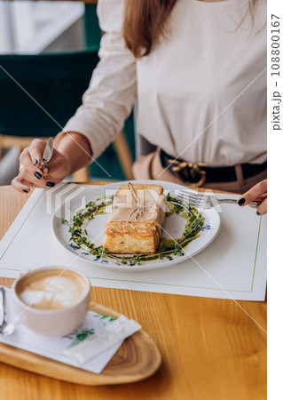 Close up of woman eating tasty sandwich with ham and cheese. Breakfast restaurant menu Close up of woman eating tasty sandwich with ham and cheese. Breakfast restaurant menu 108800167