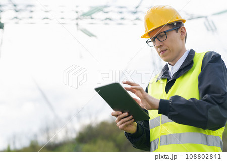 Engineer with digital tablet on a background of power line tower 108802841