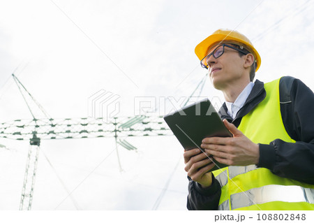 Engineer with digital tablet on a background of power line tower 108802848