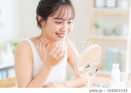 リビングでスキンケアをする若い女性 108803145