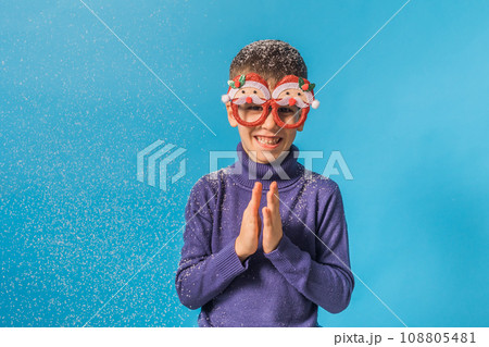 Child boy throws up snow on blue background with copy space mockup. Christmas and New Year holidays concept. Generation alpha and gen alpha children. Copy space Child boy throws up snow on blue background with copy space mockup. Christmas and New Year holidays concept. Generation alpha and gen alpha children. Copy space 108805481