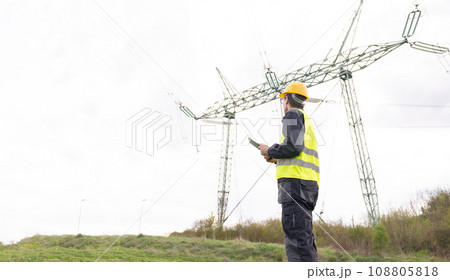 Engineer with digital tablet on a background of power line tower 108805818