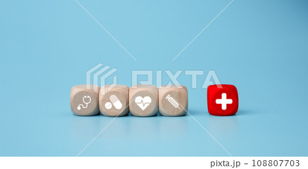 Wooden blocks with medical symbol icons on blue background representing health concept with treatment and medicine. 108807703