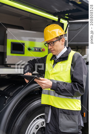Worker with digital tablet operating construction machine equipment. Worker with digital tablet operating construction machine equipment. 108808528