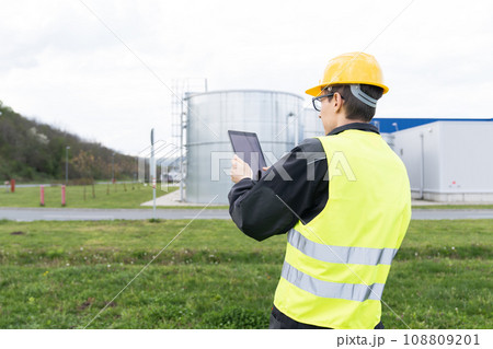 Engineer with digital tablet on a background of gas tanks 108809201
