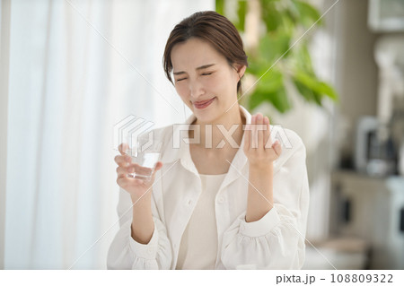 リビングで薬を飲む女性 リビングで薬を飲む女性 108809322
