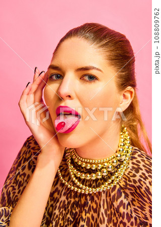 Close up portrait of woman looking at camera with capsule on her tongue. Young lady taking medications for her beauty 108809762