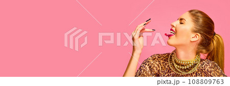 Banner. Close up side view portrait of woman put to mouth capsule, vitamin, pill, tablet isolated on pink studio background 108809763