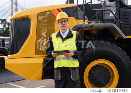 Worker in a helmet with a digital tablet 108810436