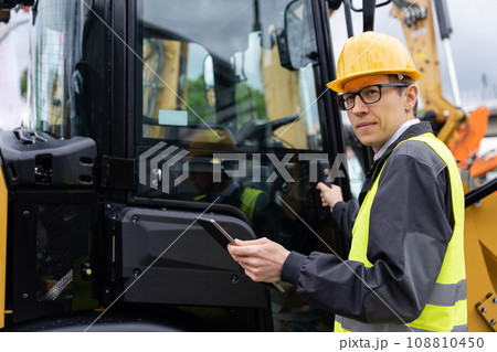 Worker in a helmet with a digital tablet 108810450