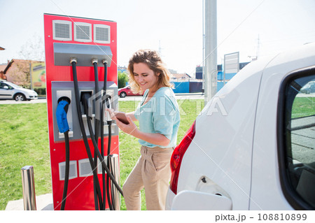 A woman stands at the charging station A woman stands at the charging station 108810899