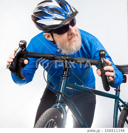 bearded man cyclist in sunglasses holds a sports bike in his hands on a light background bearded man cyclist in sunglasses holds a sports bike in his hands on a light background 108811146
