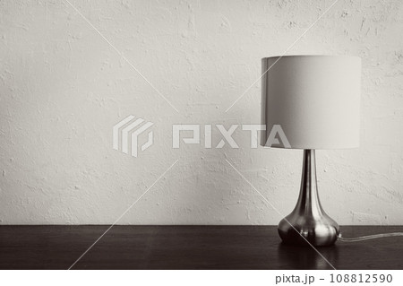 minimal simple elegant lamp on wooden table against white wall 108812590