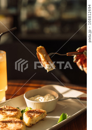 Cheesecakes with sauce with cold drink on a wooden table under sunlight Cheesecakes with sauce with cold drink on a wooden table under sunlight 108812694