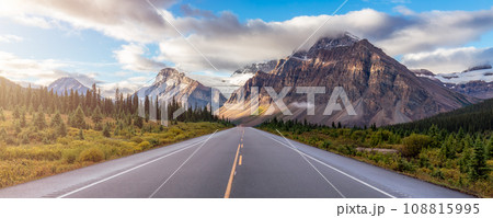 Scenic Road with green trees and Alpine Mountain Peaks in Canadian Nature Landscape. Scenic Road with green trees and Alpine Mountain Peaks in Canadian Nature Landscape. 108815995