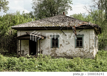 A photo of an old, dilapidated house with a crumbling roof and overgrown vegetation. A photo of an old, dilapidated house with a crumbling roof and overgrown vegetation. 108816241