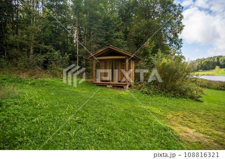 Wooden toilet in the countryside with a heart-shaped hole on the door. Wooden toilet on a background of trees. Wooden toilet in the countryside with a heart-shaped hole on the door. Wooden toilet on a background of trees. 108816321