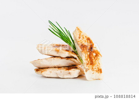 Chicken fillets fried until half cooked, semi-finished product with fresh herbs on a white background. Fast food. Quick cooking at home. Copy space.Fast cooking.Fast homemade food. 108818814