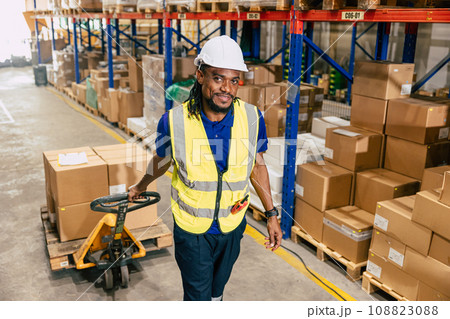 african black warehouse worker using parcel pallet moving cargo for logistics shipping supply management industry 108823088