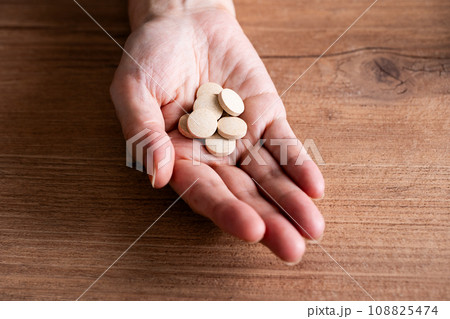 サプリを持つ手元　タブレット 108825474