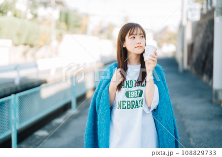 コーヒーを持ちながら街ブラする女性 108829733