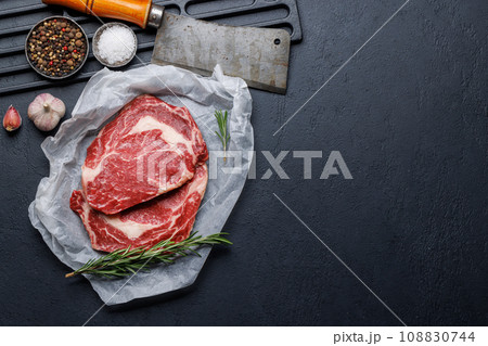 Raw ribeye steaks with savory spices 108830744