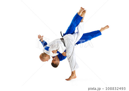 Two professional sportsmen, athletic men in in white and blue uniform performing technical skills while fighting isolated white studio background. 108832493