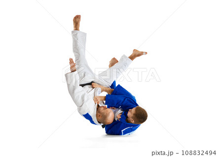 Tw fit man in uniform, professional sportsmen of martial arts, fighting, training before fight isolated white studio background. Tw fit man in uniform, professional sportsmen of martial arts, fighting, training before fight isolated white studio background. 108832494