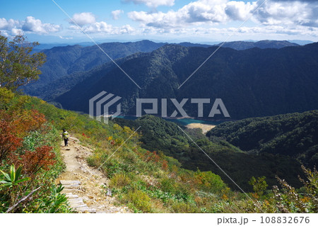 秋の平瀬登山道の稜線よりエメラルドグリーンに輝く白水湖を臨む 108832676