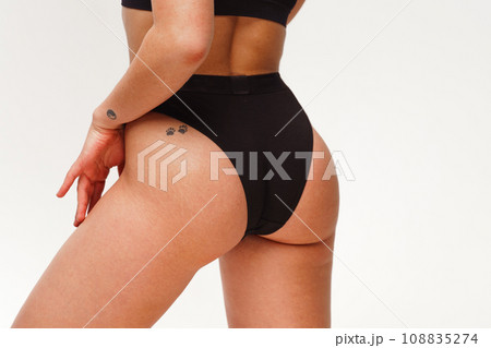 A woman with a beautiful feminine figure in black lingerie with overweight, cellulite and stretch marks. A woman with a beautiful feminine figure in black lingerie with overweight, cellulite and stretch marks. 108835274