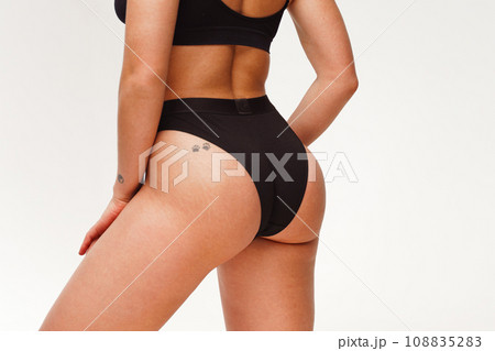 A woman with a beautiful feminine figure in black lingerie with overweight, cellulite and stretch marks. A woman with a beautiful feminine figure in black lingerie with overweight, cellulite and stretch marks. 108835283