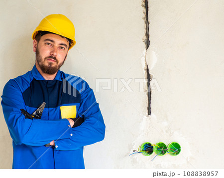 Portrait of worker or engineer in blue work clothes and yellow safety helmet Portrait of worker or engineer in blue work clothes and yellow safety helmet 108838957