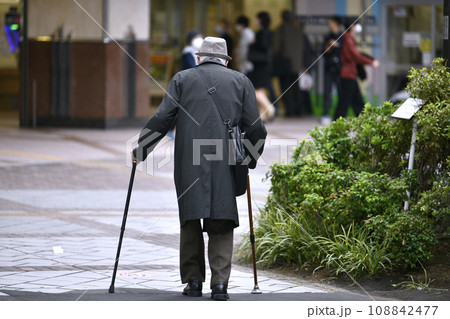 日本の横浜都市景観 高齢化社会(マスク姿で両手に杖の高齢者）＝横浜市内で（画面奥は相鉄線横浜駅） 108842477