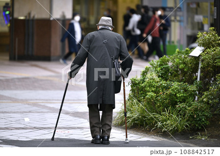 日本の横浜都市景観 高齢化社会(マスク姿で両手に杖の高齢者）＝横浜市内で（画面奥は相鉄線横浜駅） 108842517