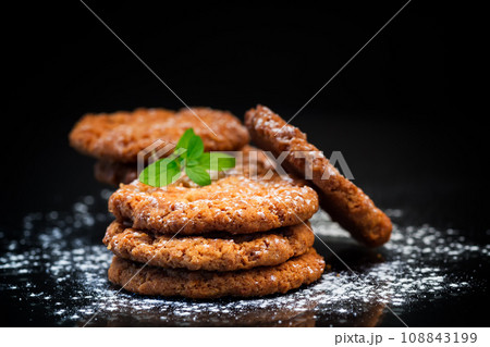 cooked sweet oatmeal cookies on black background cooked sweet oatmeal cookies on black background 108843199