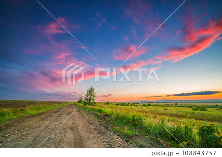 Rural landscape with ground road at beautiful summer sunset 108843757