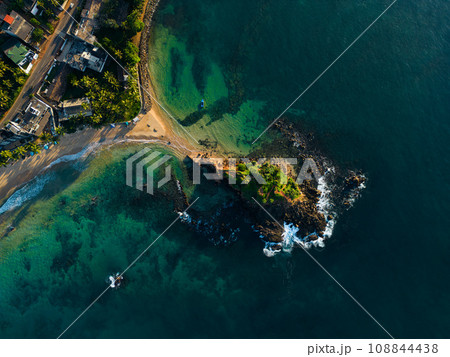 Aerial view of tranquil coastal vista with lush greenery and azure waters, ideal for travel brochures and postcards promoting serene vacations and tropical getaways. Parrot rock island in Sri Lanka. 108844438
