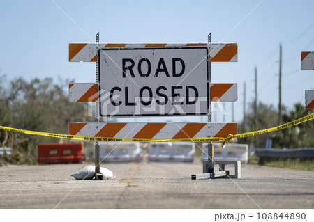 Yellow protective barrier at street construction site. Warning road sign about utility work Yellow protective barrier at street construction site. Warning road sign about utility work 108844890