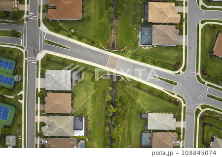 View from above of densely built residential houses in closed living clubs in south Florida. American dream homes as example of real estate development in US suburbs View from above of densely built residential houses in closed living clubs in south Florida. American dream homes as example of real estate development in US suburbs 108845074